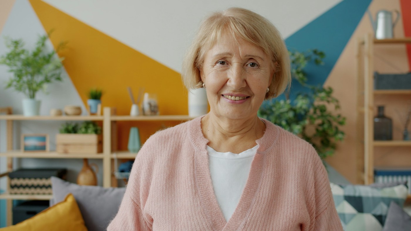 A smiling woman at home, about to start a conversation